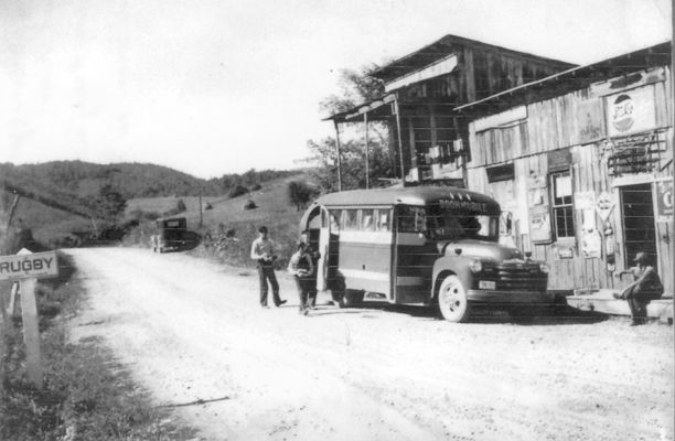 Rugby - Bookmobile Visit
This is a late 1940s or early 1950s photo showing a visit of the Grayson County Library's bookmobile to the Rugby Community.  Johnny Warren is the child coming from the bookmobile with books.  Conley Warren is standing behind Johnny.  Marvin Reedy is sitting on the porch of the store.  The other man is unidentified.  Courtesy of Judy Russell Powers.
