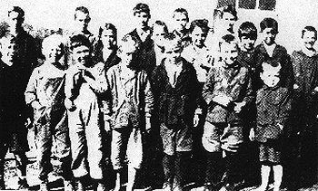 wallaceschool.jpg
Needmore (Wallace) School (Courtesy of Connie Knipp)
This is Needmore School around 1918, Carrie Countiss or Emily Holloway was the teacher. FRONT ROW LEFT TO RIGHT: Garnett Leonard, Moses Luther Goodson, Charles Thomas, Howard Goodson, Ester Leonard, Wilmer Mitchell, Malcom Mitchell. Second Row: Bertha Rush ( girl with braids), Rose Goodson ( face partly hidden), Stella McCracken ( showing her watch, it is 1 p.m.) Robert Leonard. Third Row: Howard McCracken, Samuel Mitchell, Gannaway Rush, William Goodson, Nellie Goodson, Ralph Goodson, Paul Goodson, Garnett, Esther,& Robert Leonard brothers & sister, Nellie & Ralph Goodson full brother & sister, Moses Luther Goodson, a half brother, Howard & Stella McCracken, brother & sister, Howard, Rose, William, & Paul Goodson, brother & sister, Wilmar, Malcom, & Samuel Mitchell, brothers, Gannaway & Bertha Rose, brother & sister.

