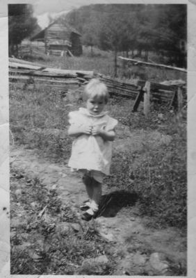 Blevins, Doris Rose
Doris Rose Blevins, daughter of Garfield Blevins and Mattie Weaver is shown here on Wolf Knob,m Grayson County,  VA.  Her grandparents, Clayborne Monoe Weaver and Martha Litisha Phipps' log cabin is seen in the background.
